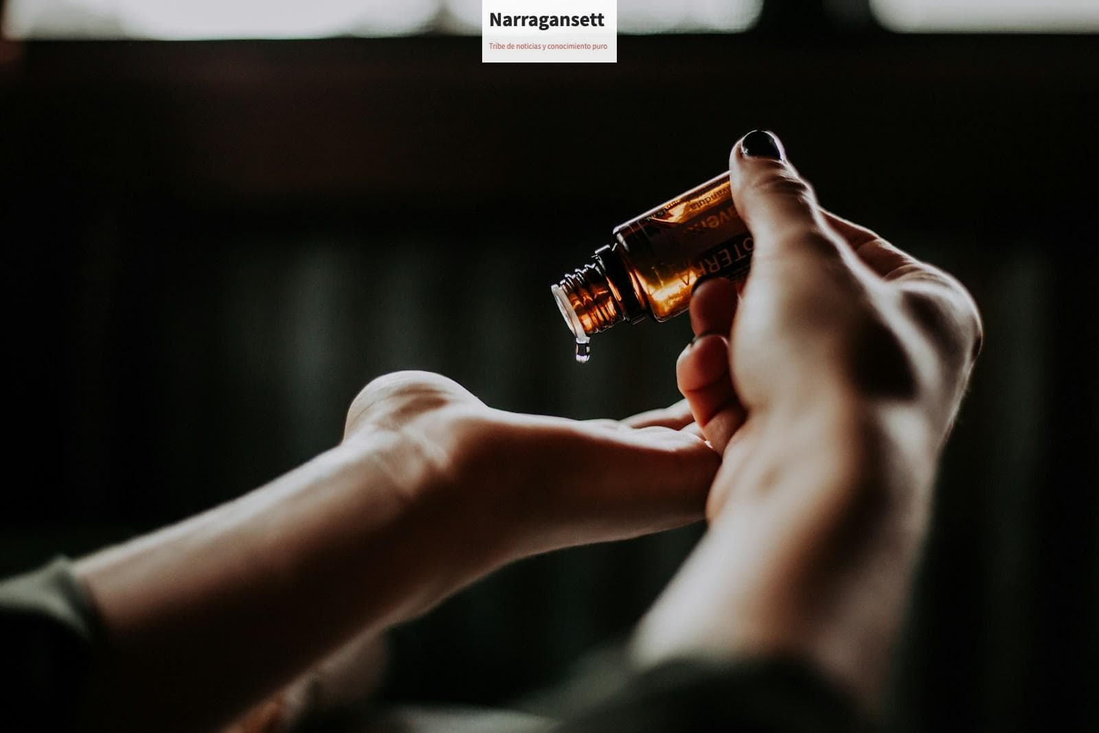 person holding amber glass bottle