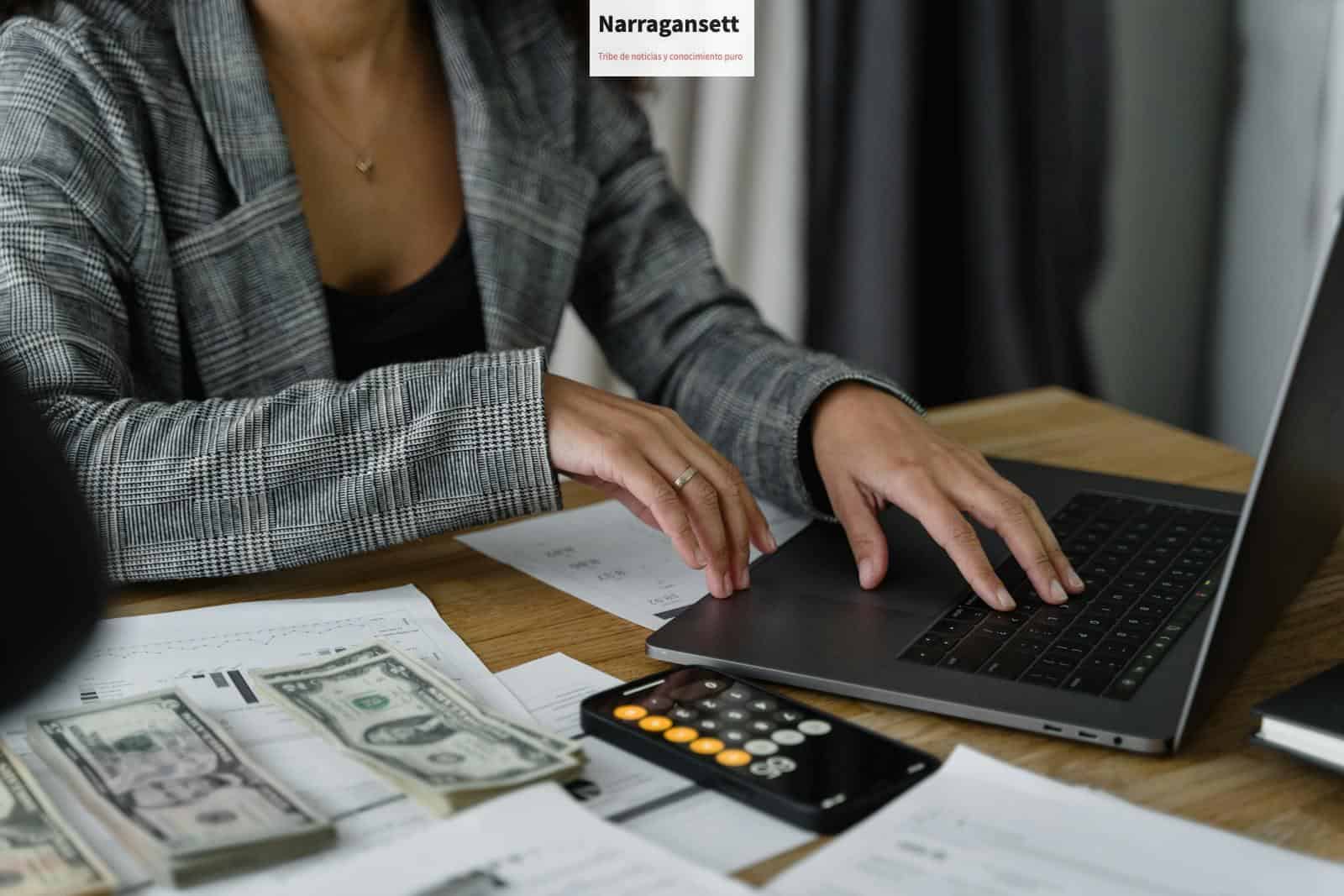A businesswoman working on finance management with cash and calculator on desk.
